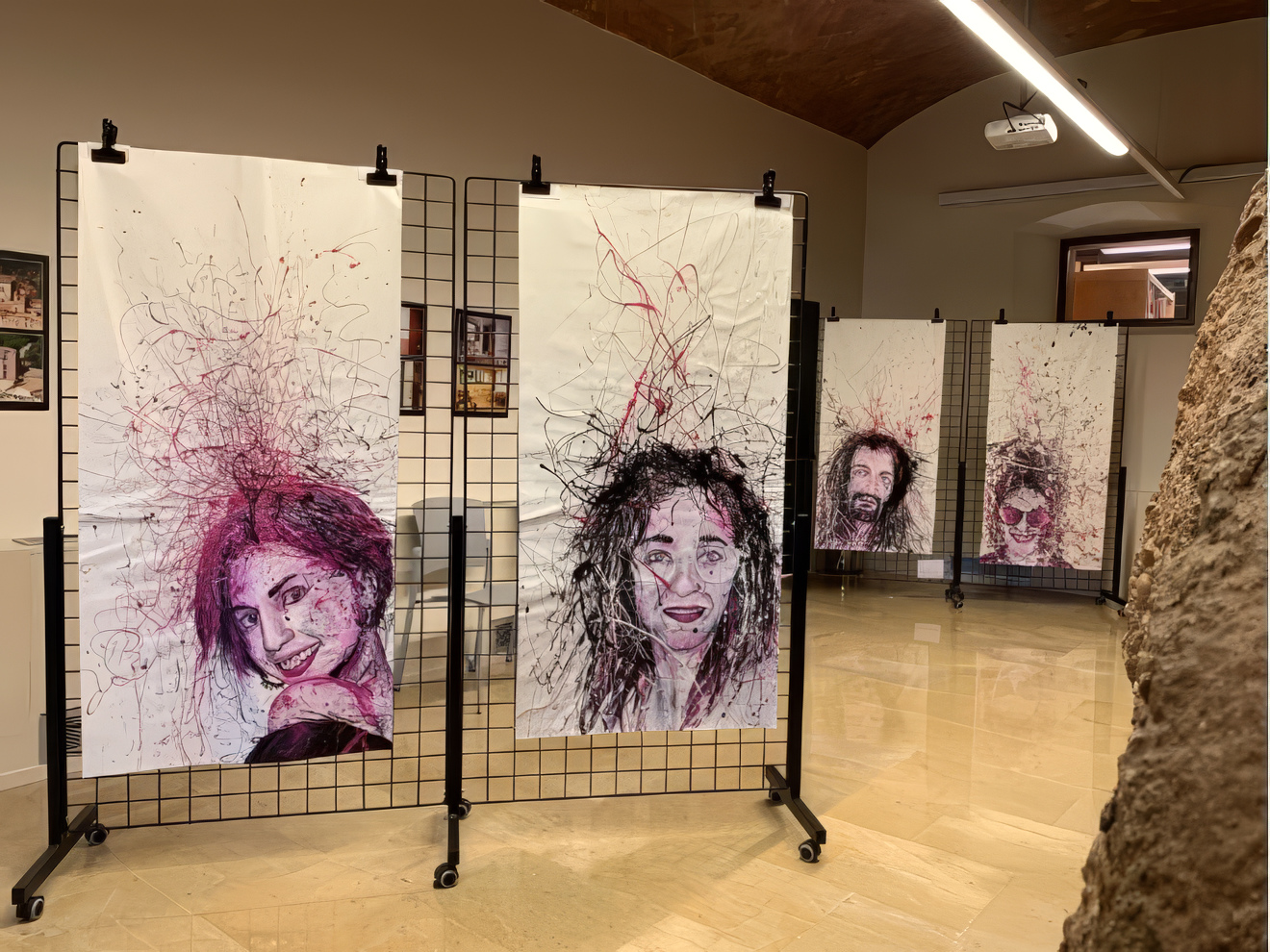 Fragments, installation view: large portraits on paper hung on black grid stands